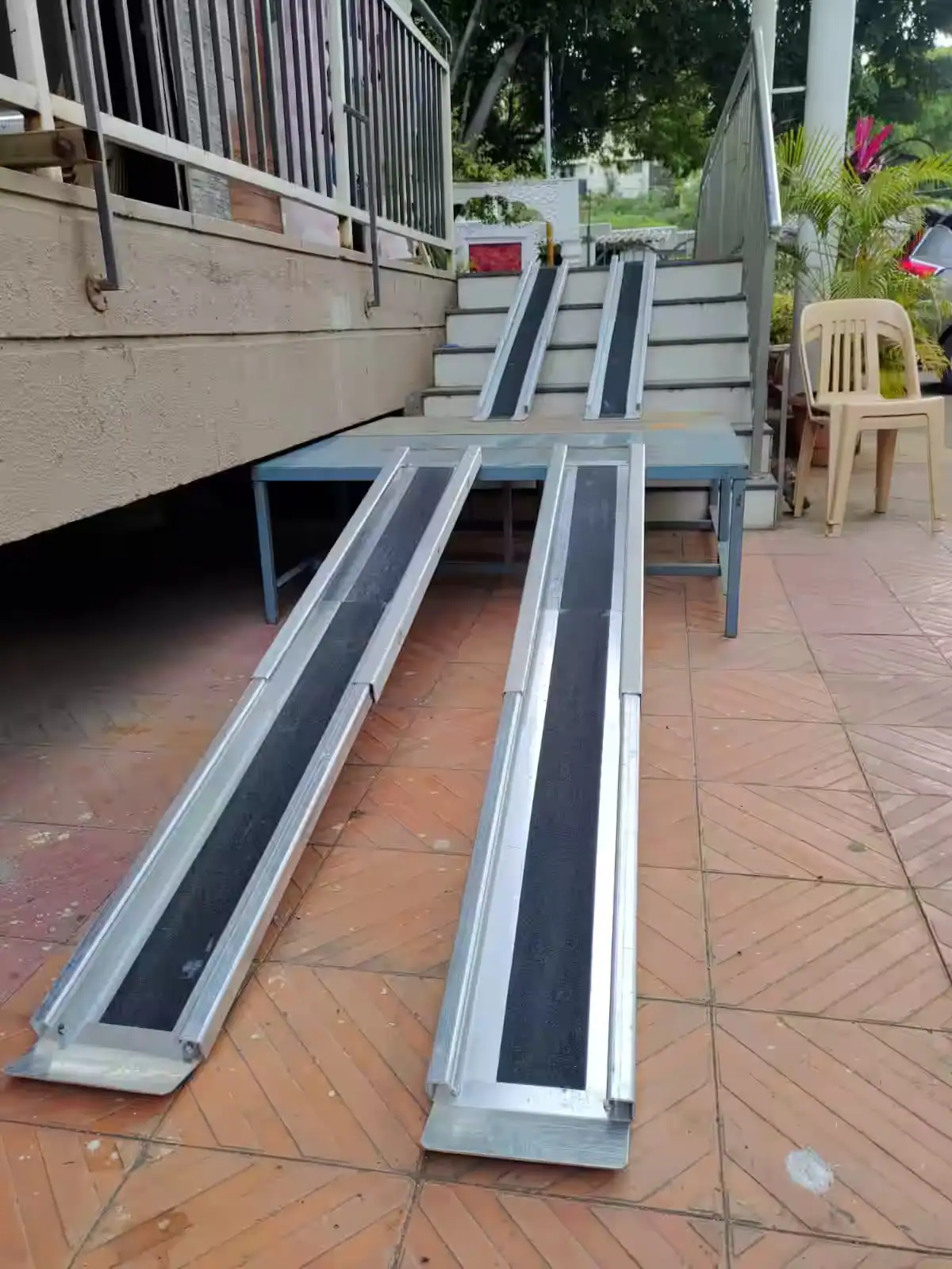 Telescopic wheelchair ramp tracks extending from a vehicle